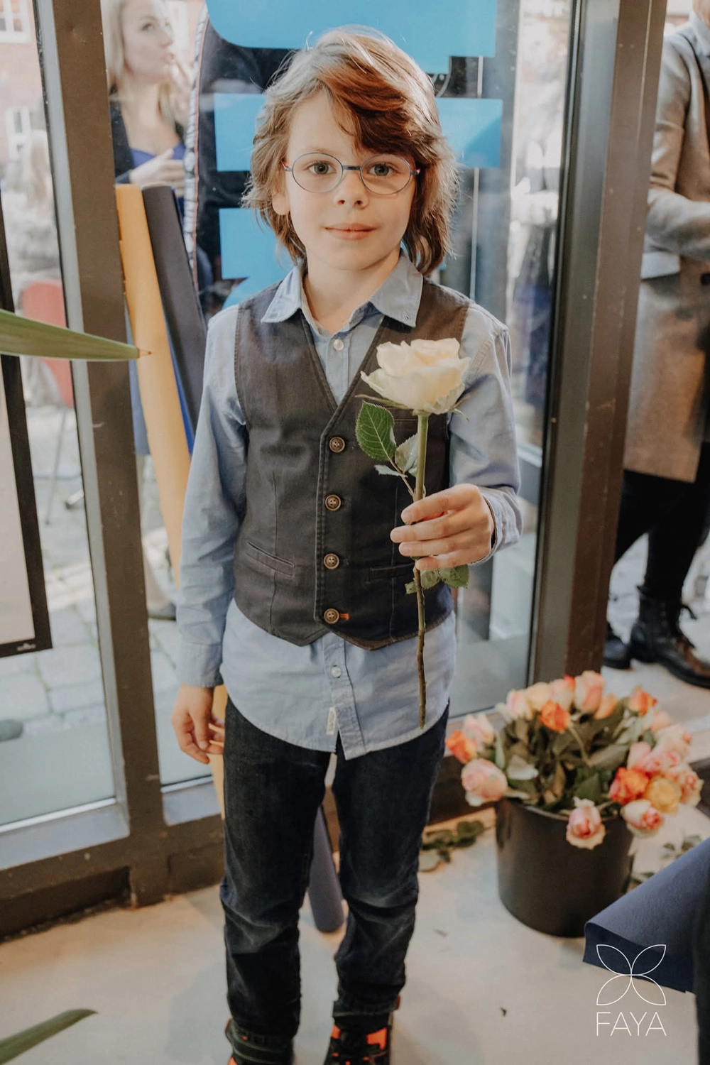 Ein Kind hält eine Blume in den Händen vom Bürgerservice für Migranten